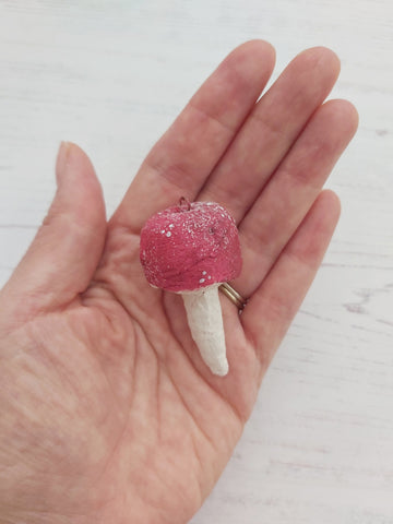 red spun cotton mushroom, held in hand