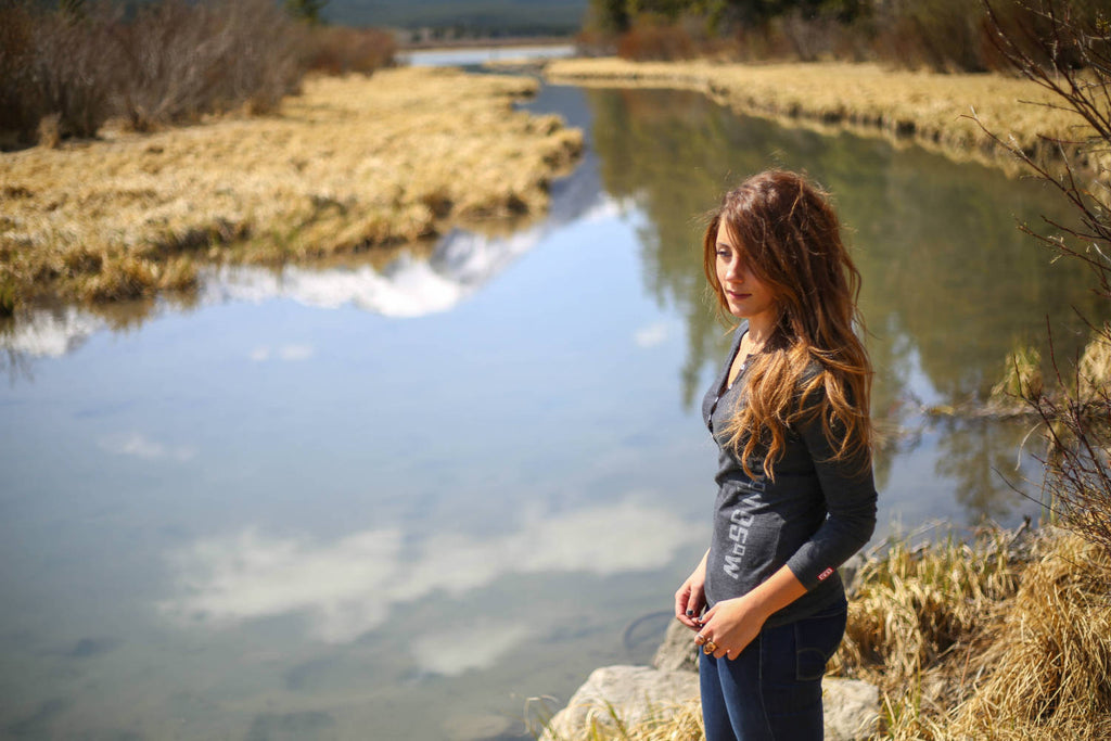 Girl wearing a black mix 5-button henley standing by a river