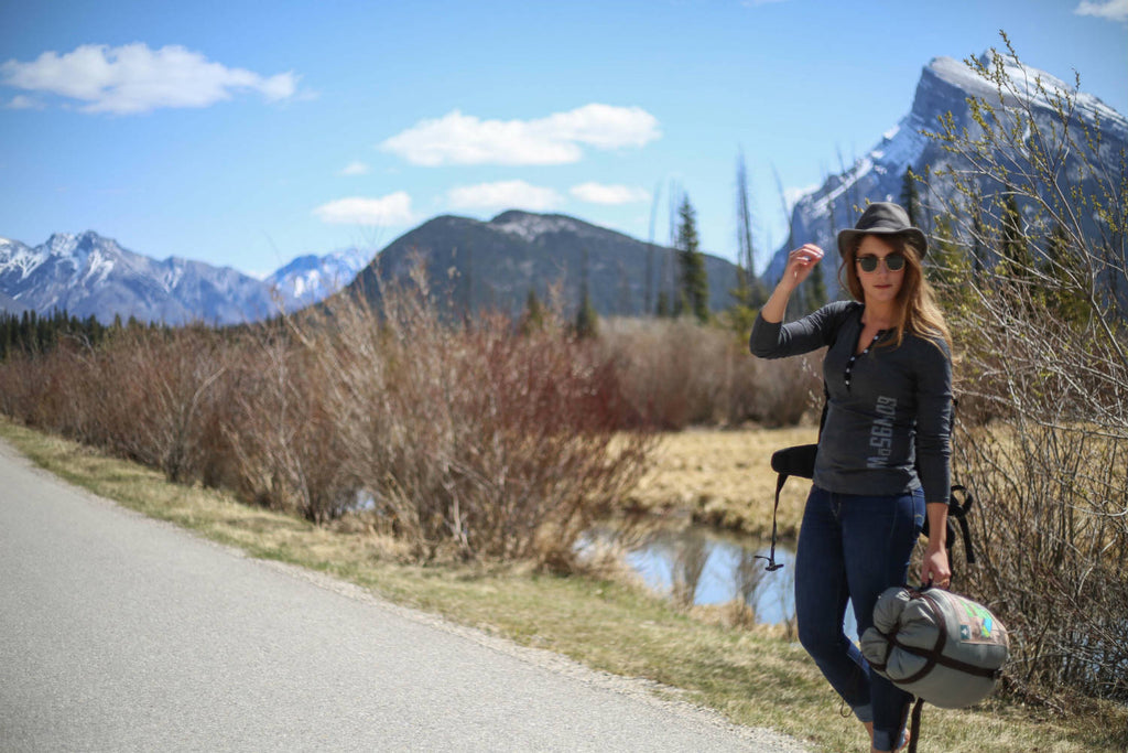 Girl wearing a black mix 5-button henley standing by the side of a road