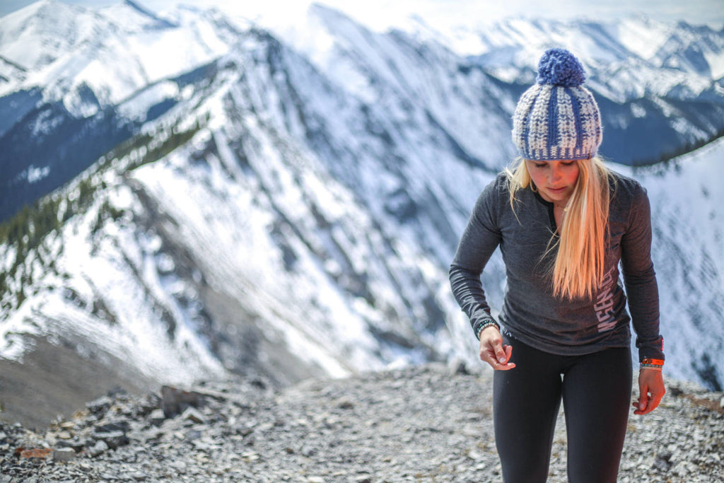 Girl walking up a snow covered mountain wearing the black mix 5-button henley