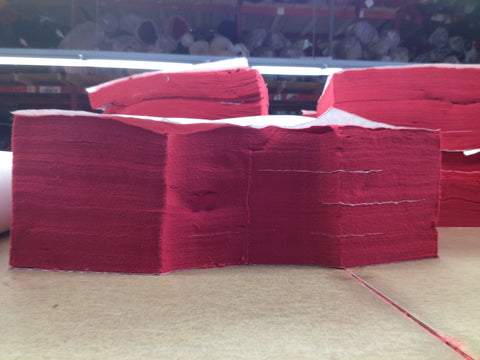 Stack of 100% cotton fabric that's been cut into panels.