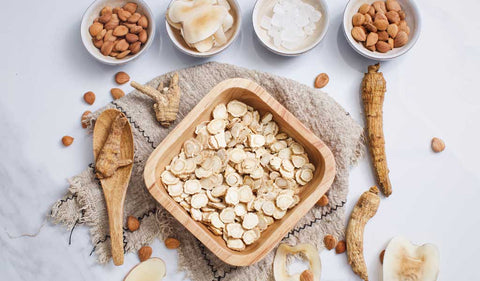 American ginseng slices in a large wooden bowl
surrounded by other ingredients in smaller
bowls