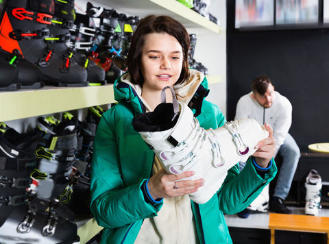 Woman chooses new ski boots at a sports equipment store