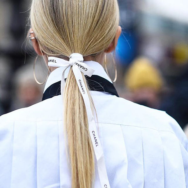 Girl with Channel white ribbon tied in hair