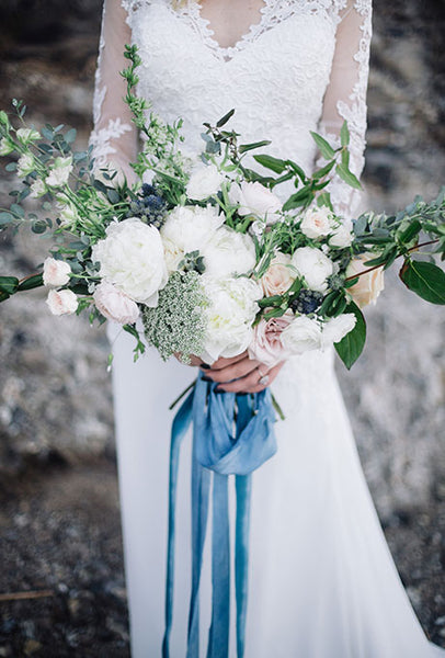 White bouquet with blue ribbon