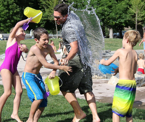 kids splashing adult with water