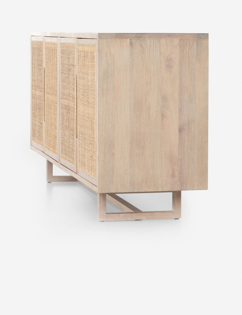 Angled side view of the Margot whitewashed natural mango wood sideboard with cane doors.