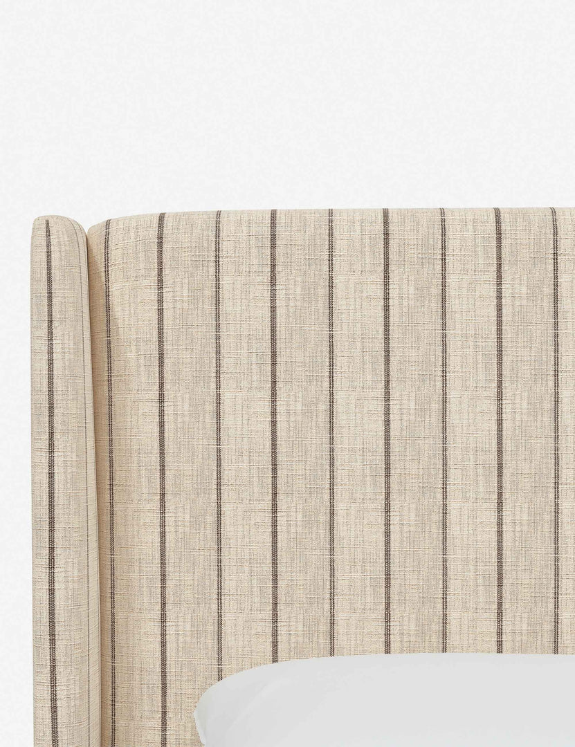 Close-up of the subtle winged headboard and trim lines on the Adara natural stripe  linen upholstered bed.