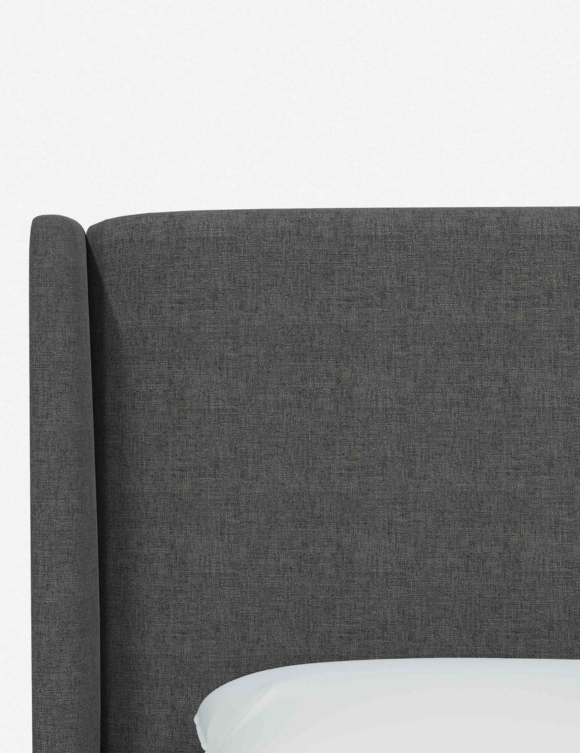 Close-up of the subtle winged headboard and trim lines on the Adara gray linen upholstered bed.