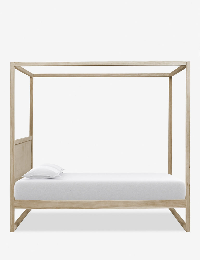 Side view of the Kiery light wood canopy bed