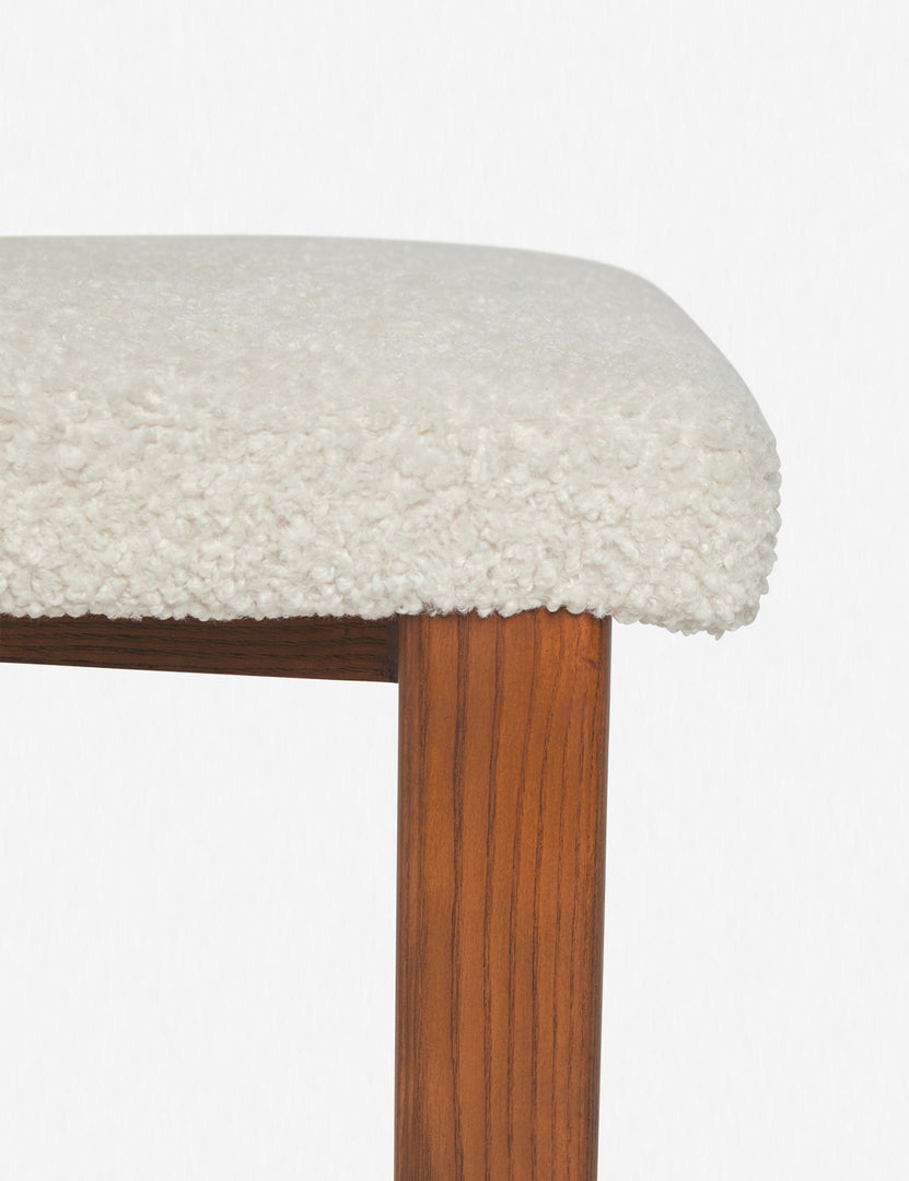 Detailed view of the ash wood legs and the plush cushioning on the seat of the Sydney white plush armless dining chair