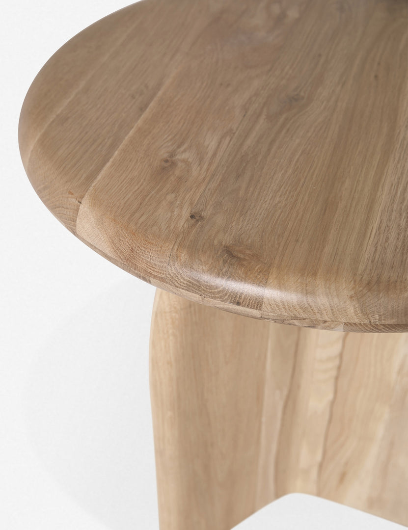 Close-up of the top edge on the Ada solid oak side table with oval top and curved pedestal base