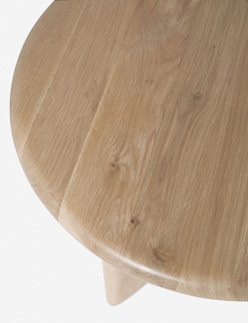 Close-up of the top edge on the Ada solid oak side table with oval top and curved pedestal base