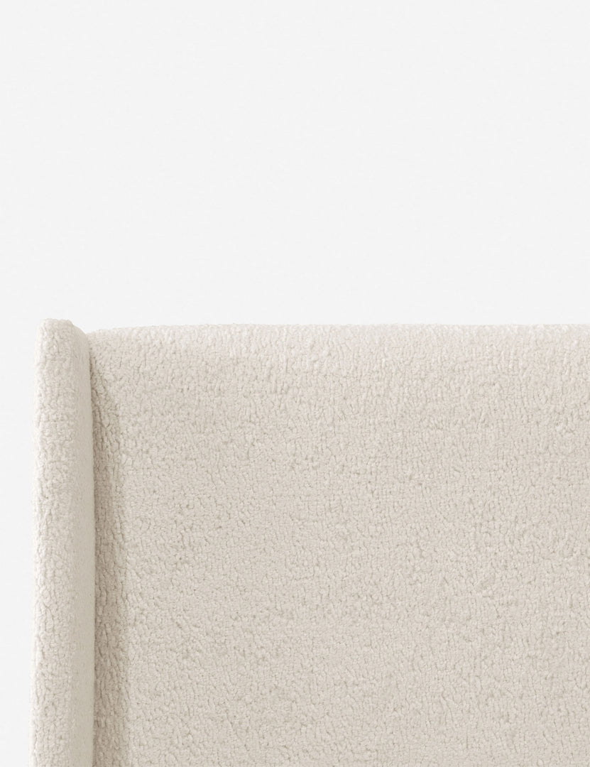 Close-up of the subtle winged headboard and trim lines on the Adara cream sherpa upholstered bed.