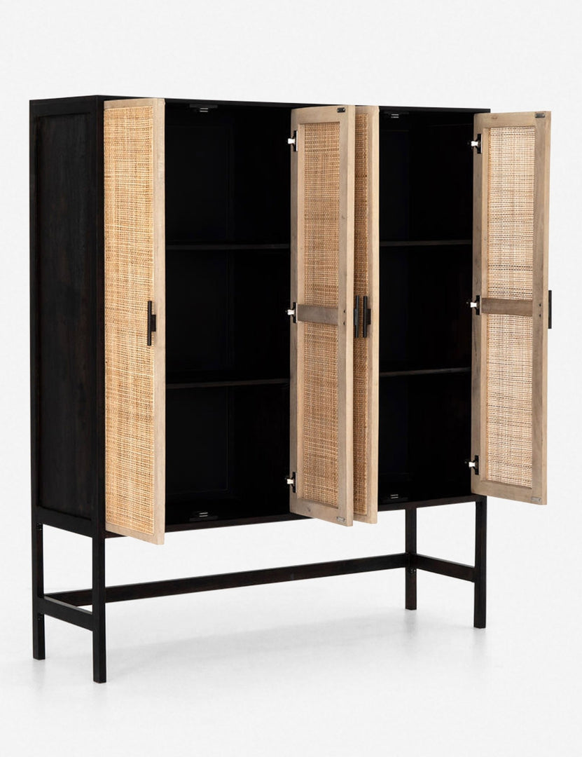 Angled view of the Hannah black mango wood cabinet with cane doors with all four doors open revealing the inner shelving