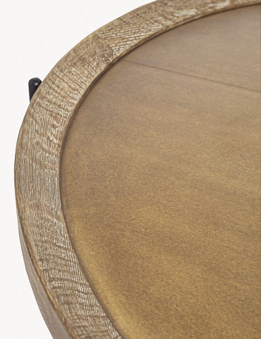 Detailed view of the rimmed surface and the texture of the wood on the Becca coffee table with rimmed oak top and iron tripod-style base