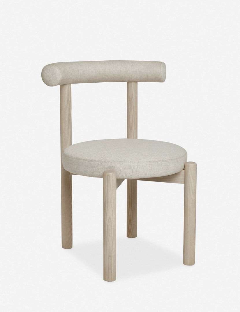 Angled left view of the Dame minimalist rounded open-back dining chair with ivory upholstered seat and ash wood frame
