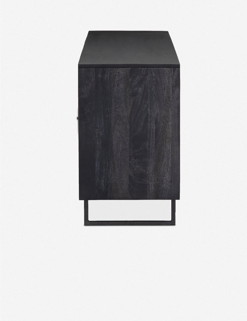 Side view of the Hannah black mango wood sideboard with cane doors and an iron base.