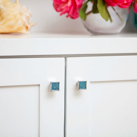 Square cabinet knobs with aqua blue crystals in white cabinet doors