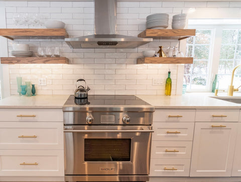 white kitchen with subway tile backsplash and brass cabinet pulls