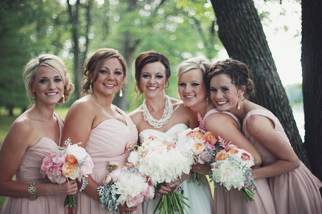 The bridal party wore gorgeous one-shoulder, chiffon bridesmaid dresses in blush. | A Whimsical Gold and Pink Wedding Day