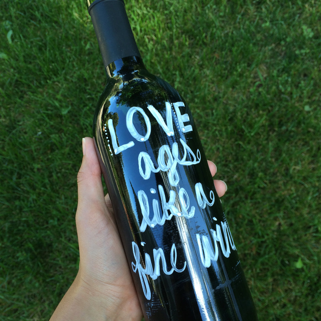 Painted text on wine bottles will look gorgeous as part of a centerpiece. | Ways to Use Love Quotes For Weddings