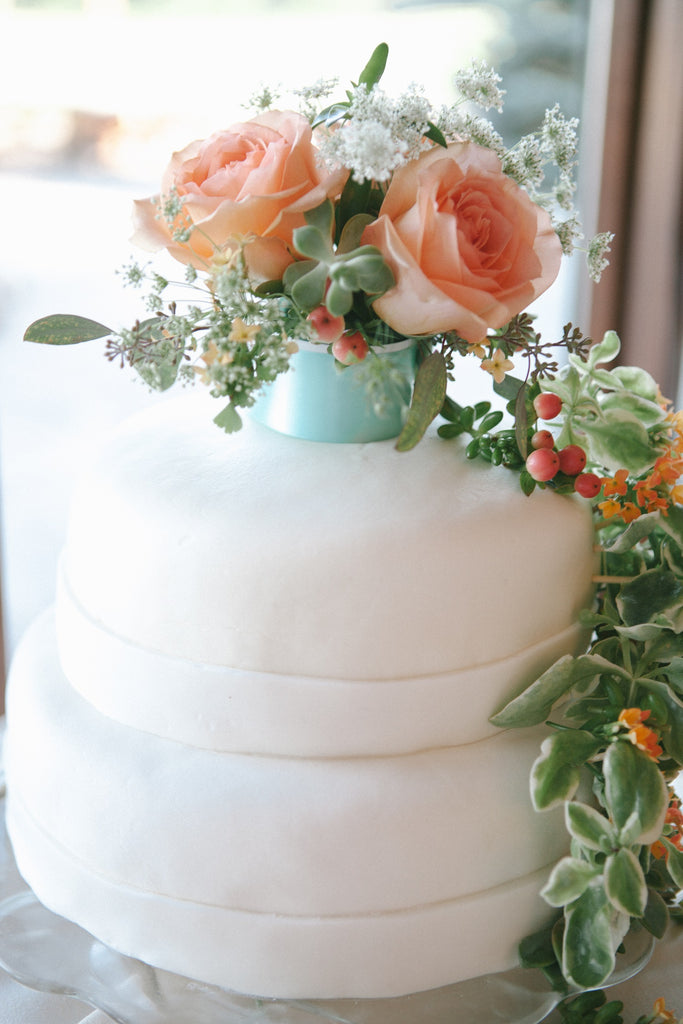 A simple white wedding cake with decorative flowers. | An Outdoor Wedding That’s Simply Charming | Kennedy Blue