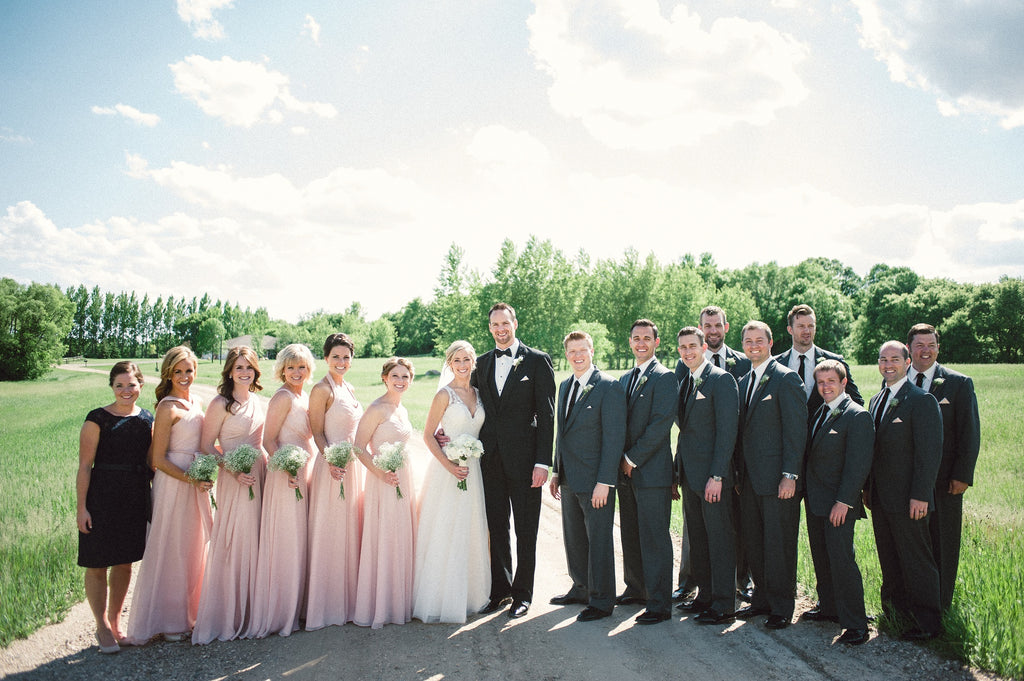Blush pink bridesmaid dresses with dark grey suits.