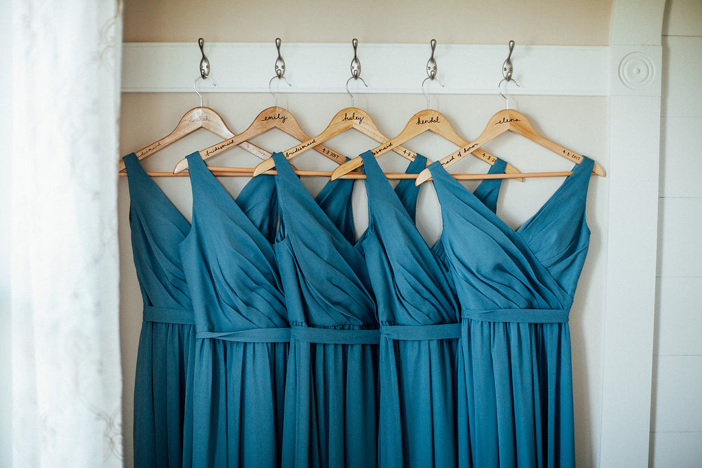 Teal-Bridesmaid-Dresses-hanging-customized-hangers-Emily-Caleb-Featured-BrideStory-Real-Wedding