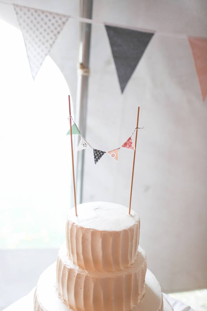 A simple wedding cake with a bunting cake topper. | A Whimsical Autumn Wedding | See the full gallery here!