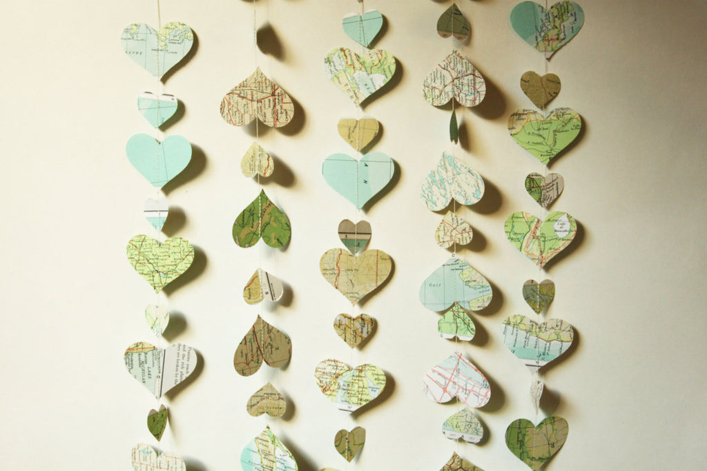 A heart map garland would make the perfect ceremony backdrop | Ways to Use Maps and Globes in Your Wedding Decor