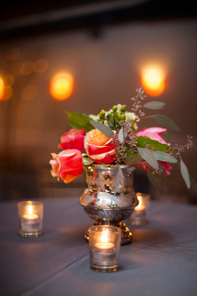 A gorgeous winter bouquet with silver votives make for a gorgeous wedding centerpiece. | A Romantic Winter-Themed Wedding