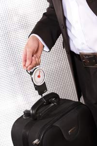 Man weighing his luggage with portable luggage scale