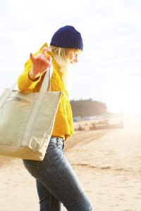 Woman Walking on Beach on Cold Day wearing Yellow Jacket Design Go