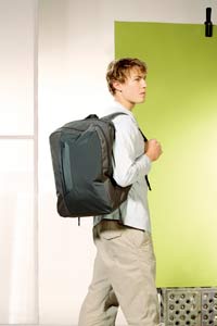 Young man walking through airport with backpack Design Go