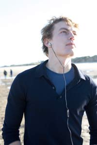 Man walking on beach with headphones Design Go