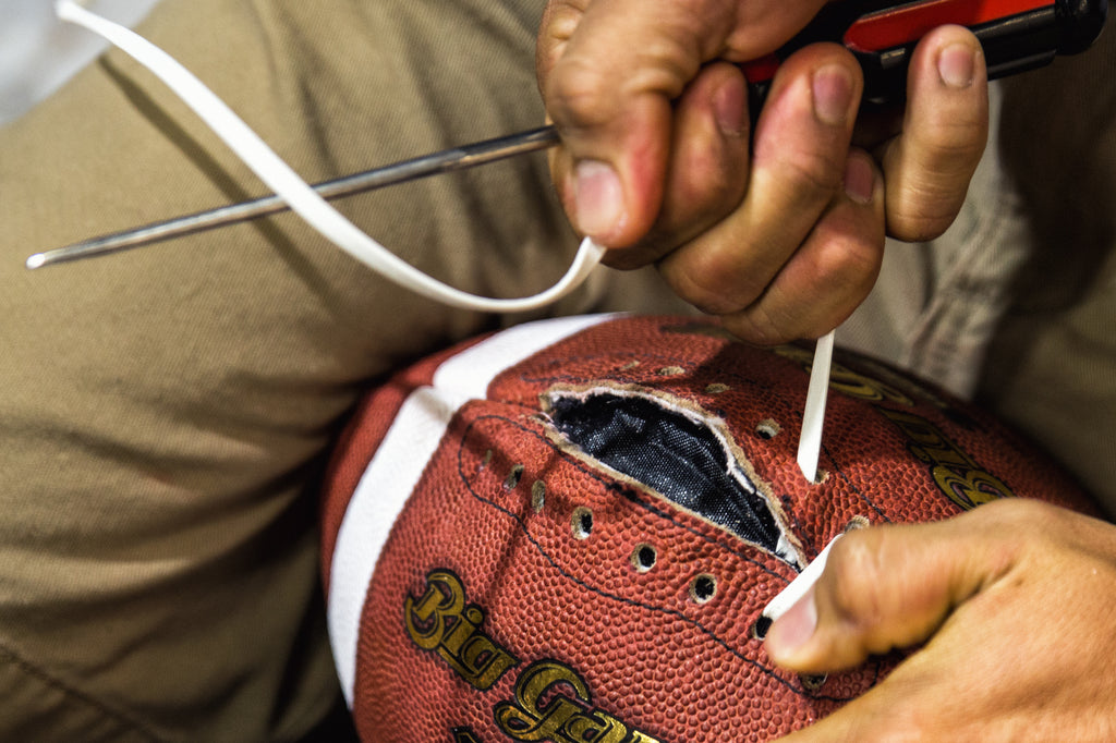 Laces being threaded on Big Game's footballs