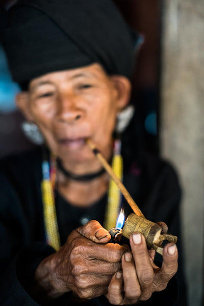 Photographie d'une femme fumant sa pipe en voyage au Myanmar