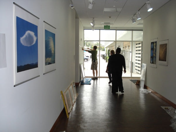 Installing Chris Garland Skyscapes exhibit with posterhanger at Annenberg Community Beach House