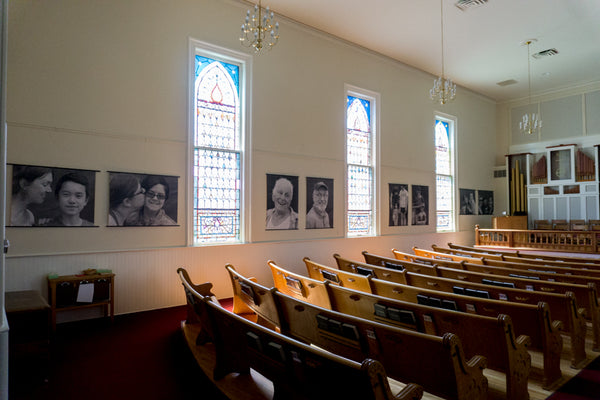 John Snell photo exhibition displayed with posterhanger inside a classic New England church sanctuary
