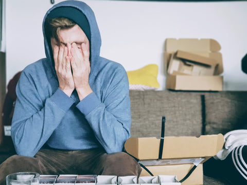 man with his hands covering his face showing he is stressed. 