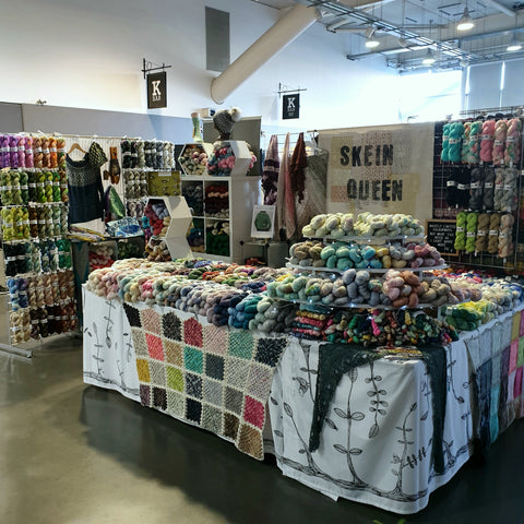 Skein Queen Stand at Southern Wool Show 2020 with lots of skeins of yarn in a rainbow of colours