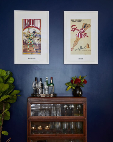 dark blue wall with mid century bar unit and vintage art prints