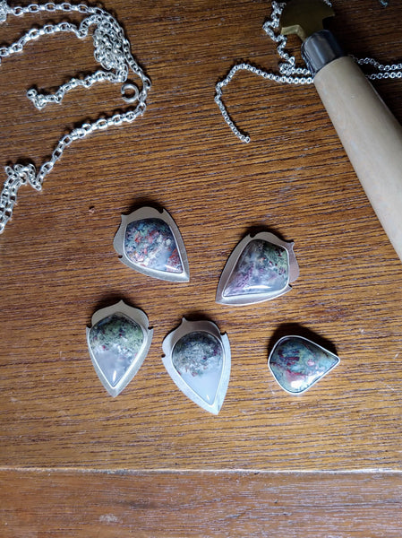 moss agate work in progress pendants with silver chain and silver smithing tools