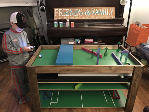 Little boy playing with activity table with Sphero Mini.