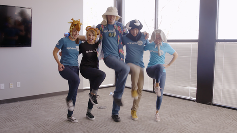 Five Sphero employees dancing together.