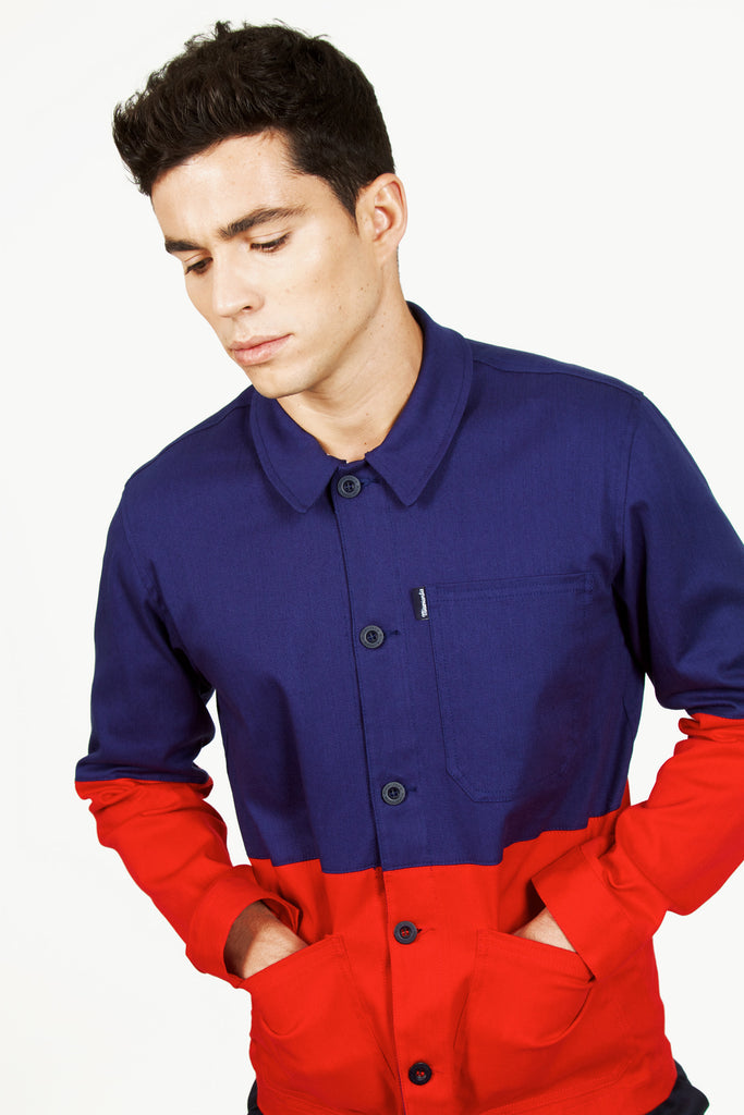 Mannequin homme regardant vers le bas, fière de porter une veste bleu de travail bicolor boutonnée en coton tendance et originale, color-block