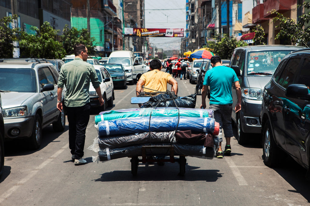 Aurelyen de dos, marchant dans les rues de Lima, scooters voitures voyage de découverte et dépaysement 