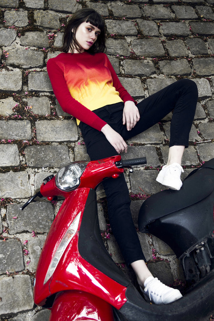 Collection hiver 2015 Misericordia jeune femme et son scooter rouge, porte un pull dégradé rouge couleur feu