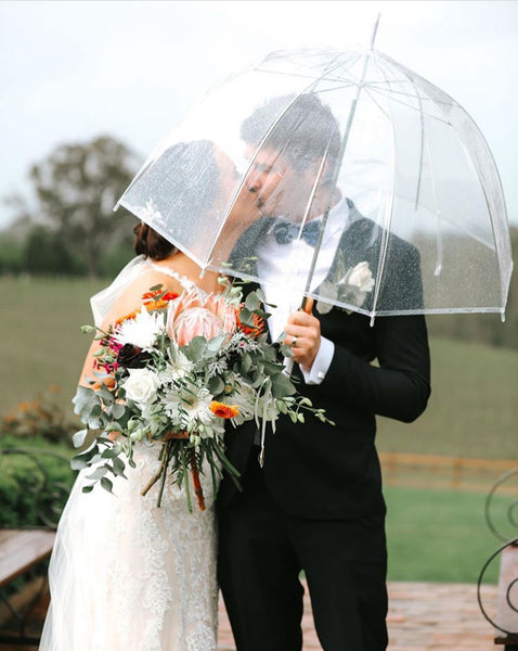 Bride and Groom underneath Signature Clear Bubble Umbrella